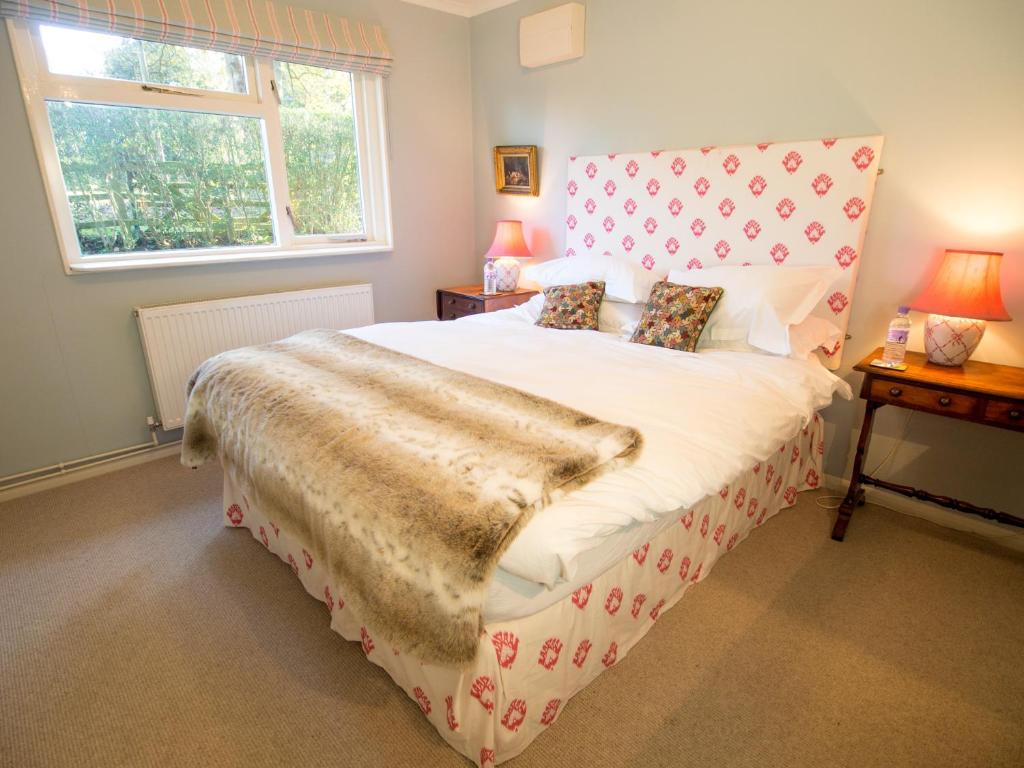 MaidfordYew Tree Cottage的一间卧室设有一张大床和大窗户