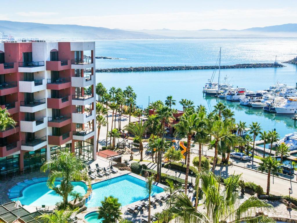 恩塞纳达港珊瑚码头酒店的享有带游泳池和码头的度假村的空中景致
