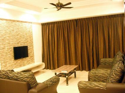 金马仑高原莱西皇冠御庭公寓的客厅配有两张沙发和一台电视