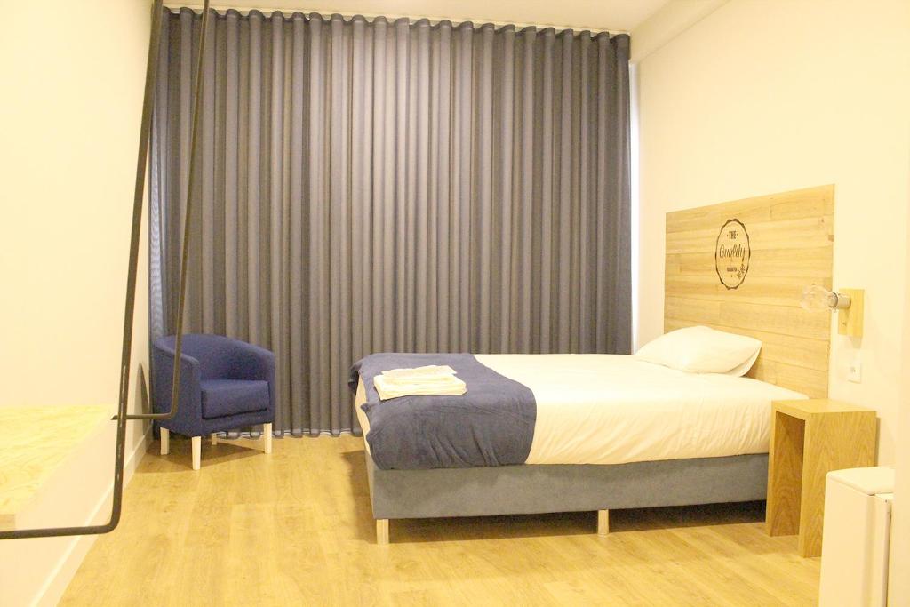 维拉诺瓦-德法马利HI!GO的一间卧室配有一张床和一张蓝色椅子