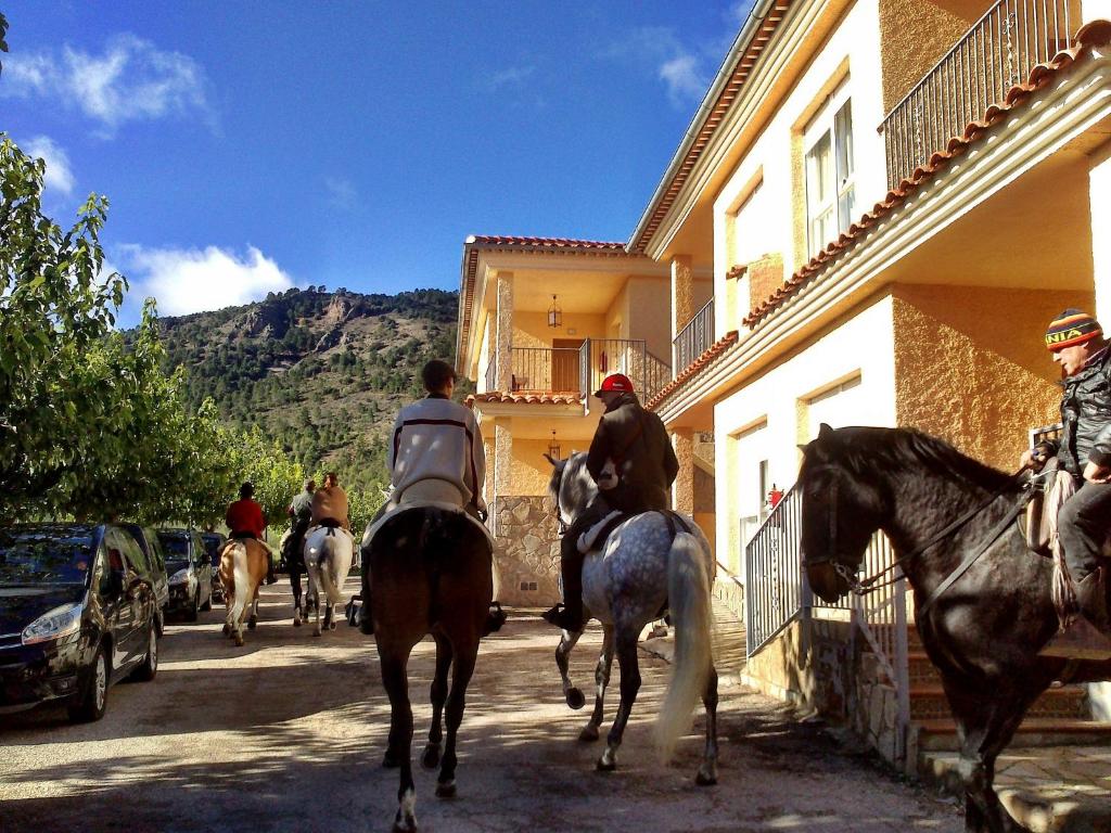 Las Casas de HachesApartamentos rurales Casas de Haches的一群骑马的人在街上骑着马