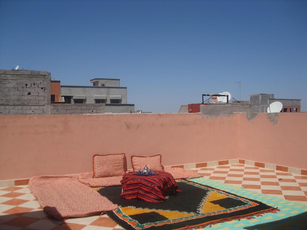 泰赫瑙特Dar Aicha的一间房间,配有两把椅子和墙上的地毯