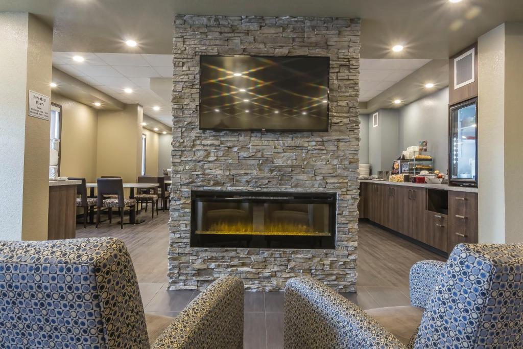 穆斯乔Quality Inn & Suites的大堂设有壁炉,上面配有电视。
