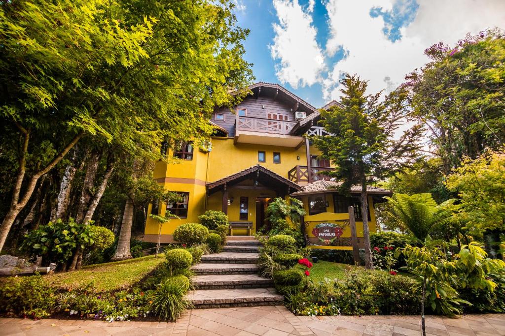 格拉玛多Pousada Das Papoulas的黄色房子前面有走道