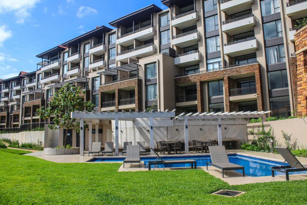 巴利托204 Zimbali Suites的公寓大楼设有游泳池和椅子