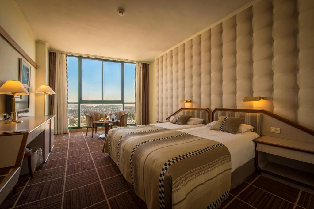 耶路撒冷Shalom Jerusalem Hotel的酒店客房设有一张床和一个大窗户