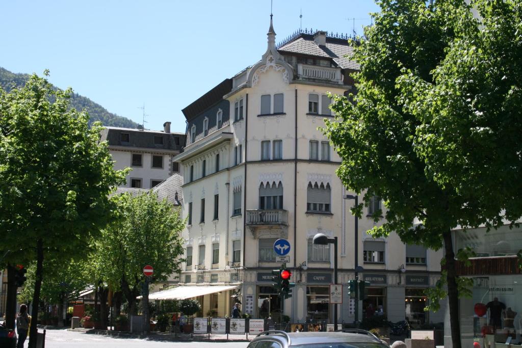 蒂拉诺Bernina Express Eco Rooms&Breakfast的一座白色的大建筑,前面有一辆汽车
