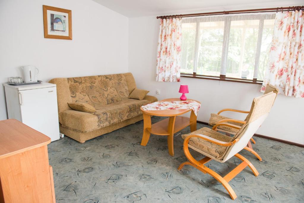 米科瓦伊基Ośrodek Wypoczynkowy Wagabunda的客厅配有沙发和桌椅