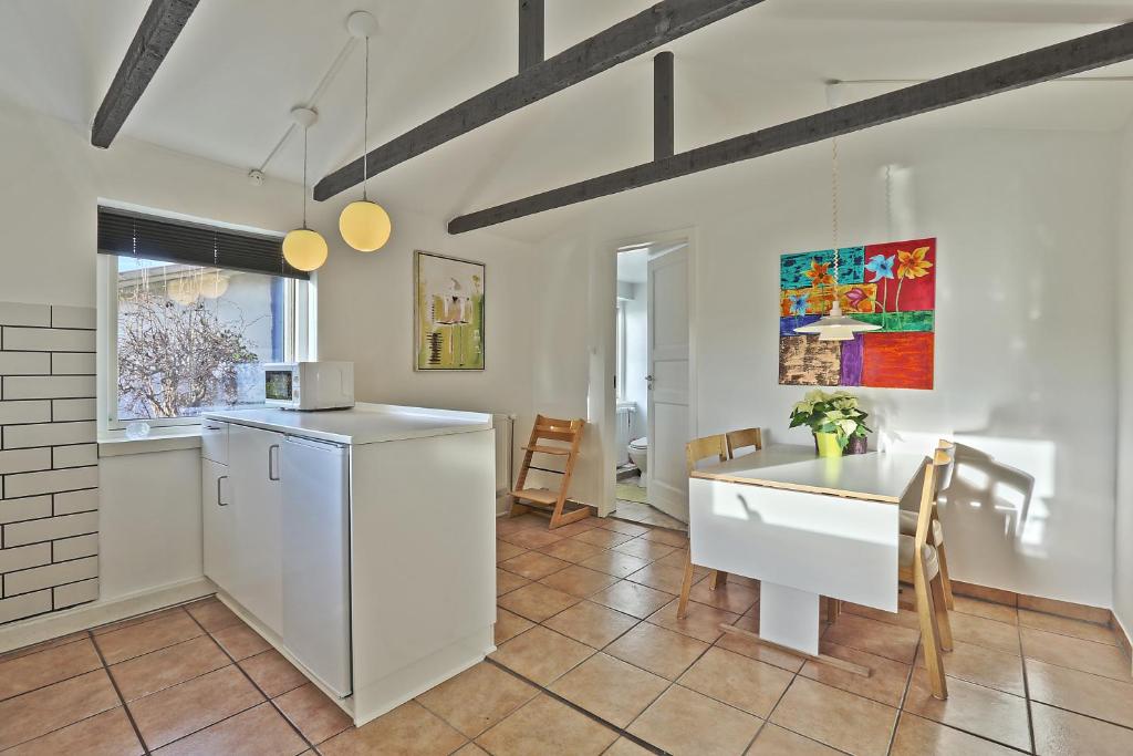 伊肖伊斯特朗登公寓的厨房配有桌子和白色冰箱。