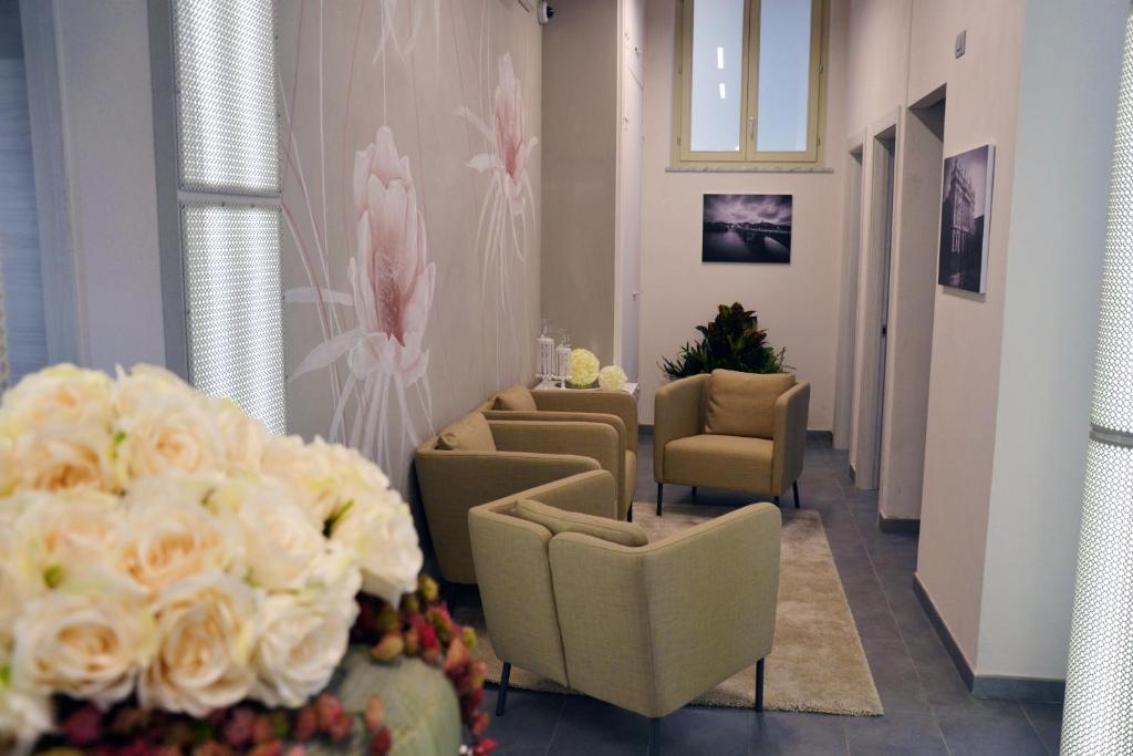 都灵Hotel Sant'Anna的等候室里带椅子和鲜花的等候区