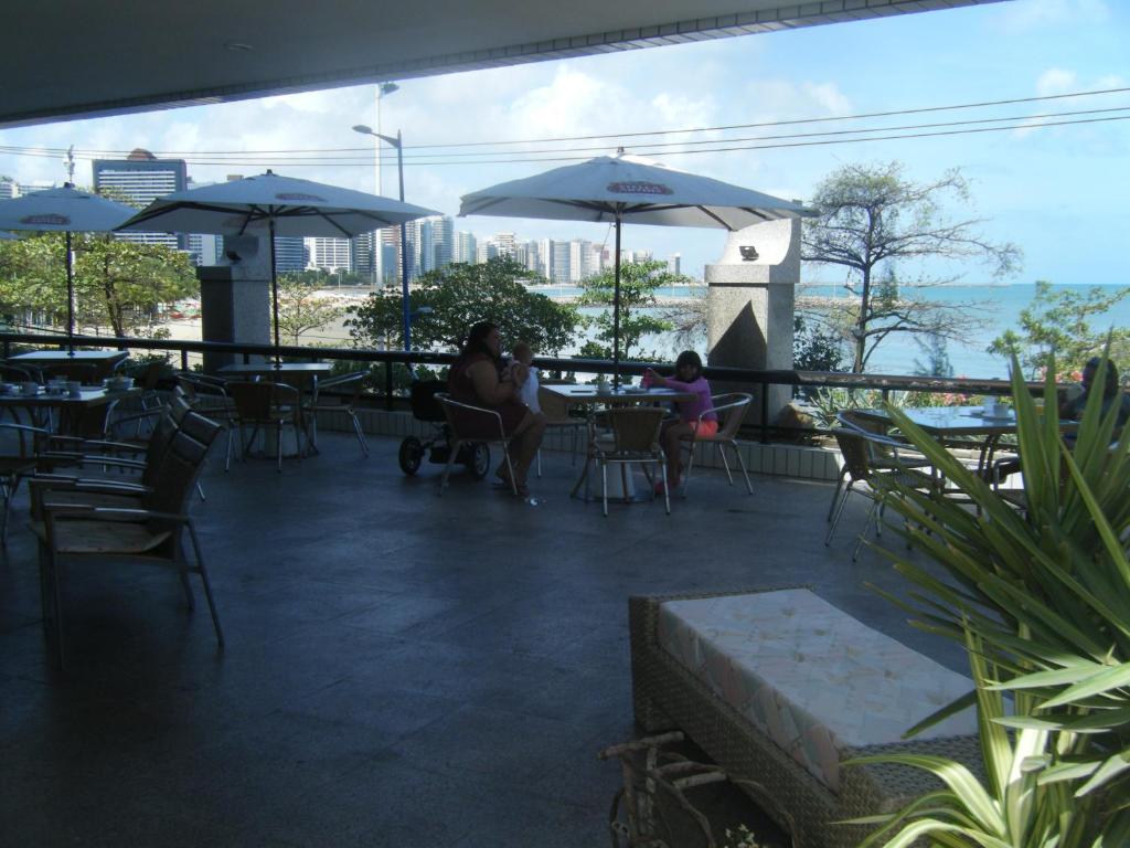 福塔莱萨Fortaleza 703--Fortaleza 713的两人坐在带桌子和遮阳伞的庭院