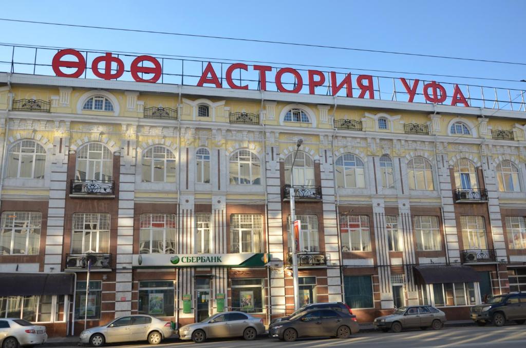 乌法Гостиница Уфа-Астория的一座大型建筑,前面有汽车停放