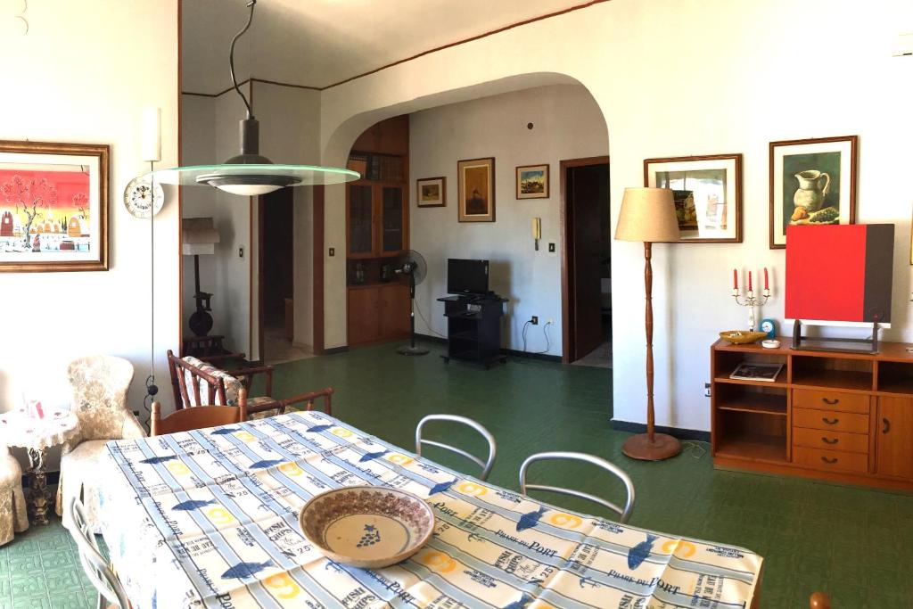 锡拉库扎Living House的一间设有桌子和绿色地板的用餐室
