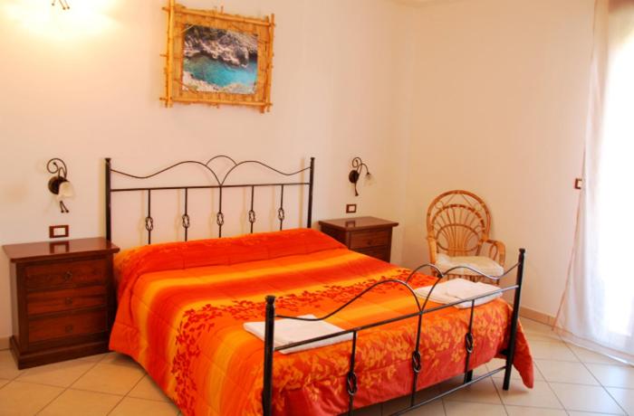 科尔萨诺诺提萨伦汀酒店的一间卧室配有一张大床和一把椅子