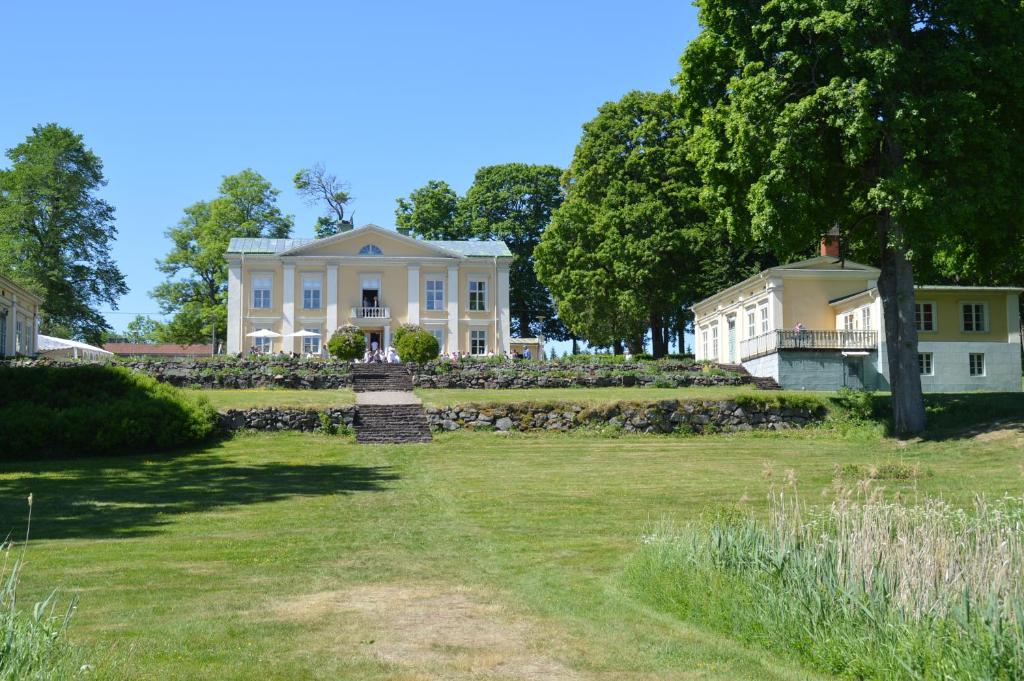 AsaAsa Herrgård的一座带草地庭院的大型白色房屋