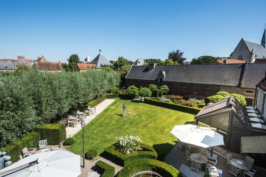 鲁汶贝居安会酒店的享有带桌椅的花园的空中景致。