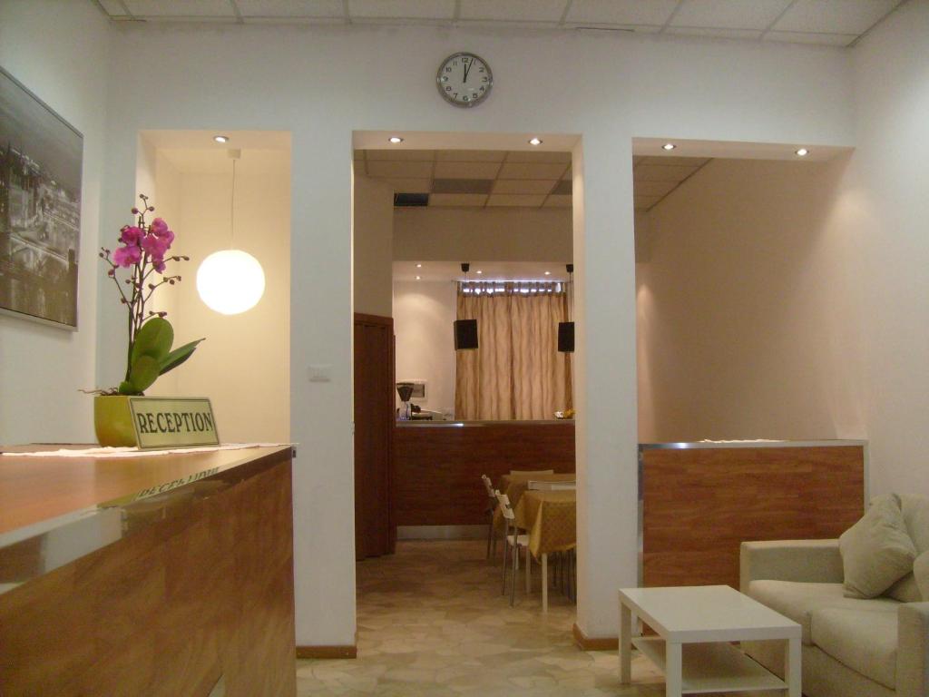 米兰欧洲住宿加早餐酒店的一间设有桌子和墙上时钟的等候室