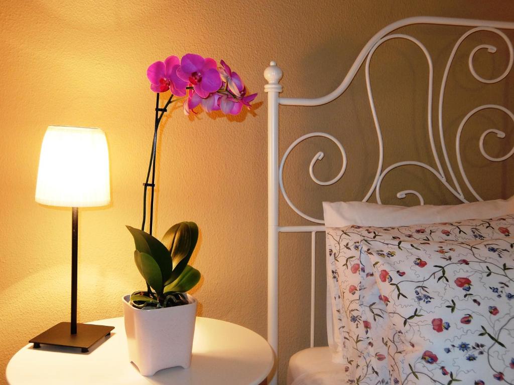利亚内斯卡萨科提鲁别墅的一间卧室,配有一张带台灯和一张桌子上的花的床铺