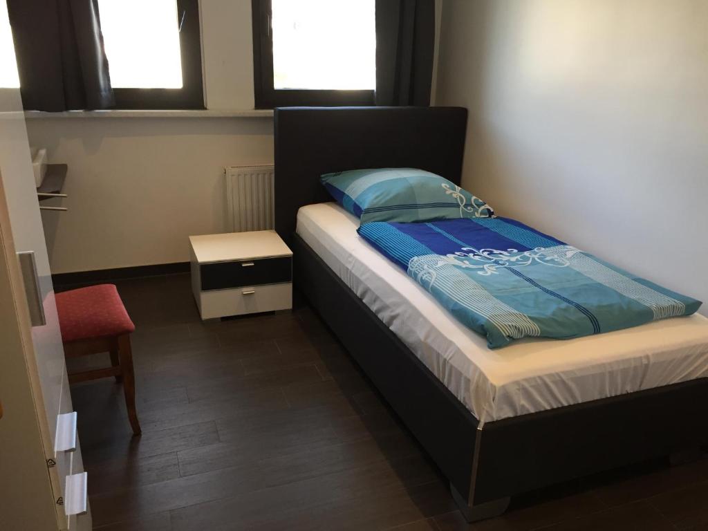 多特蒙德克罗地亚餐厅酒店的一间卧室配有一张带蓝色棉被的床