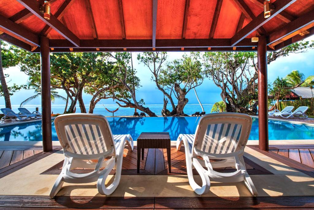 科罗雷乌毛伊岛棕榈酒店的一个带两把椅子和一张桌子的庭院和一个游泳池
