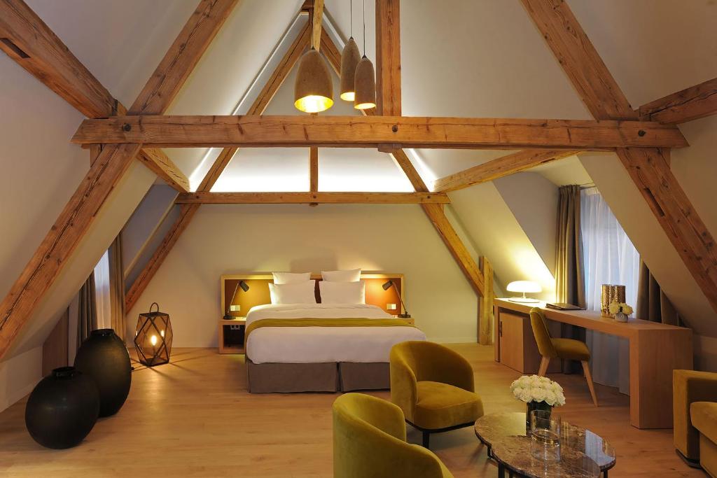 巴尔5 Terres Hôtel & Spa Barr - MGallery Hotel Collection的一间卧室,卧室内配有一张床和椅子