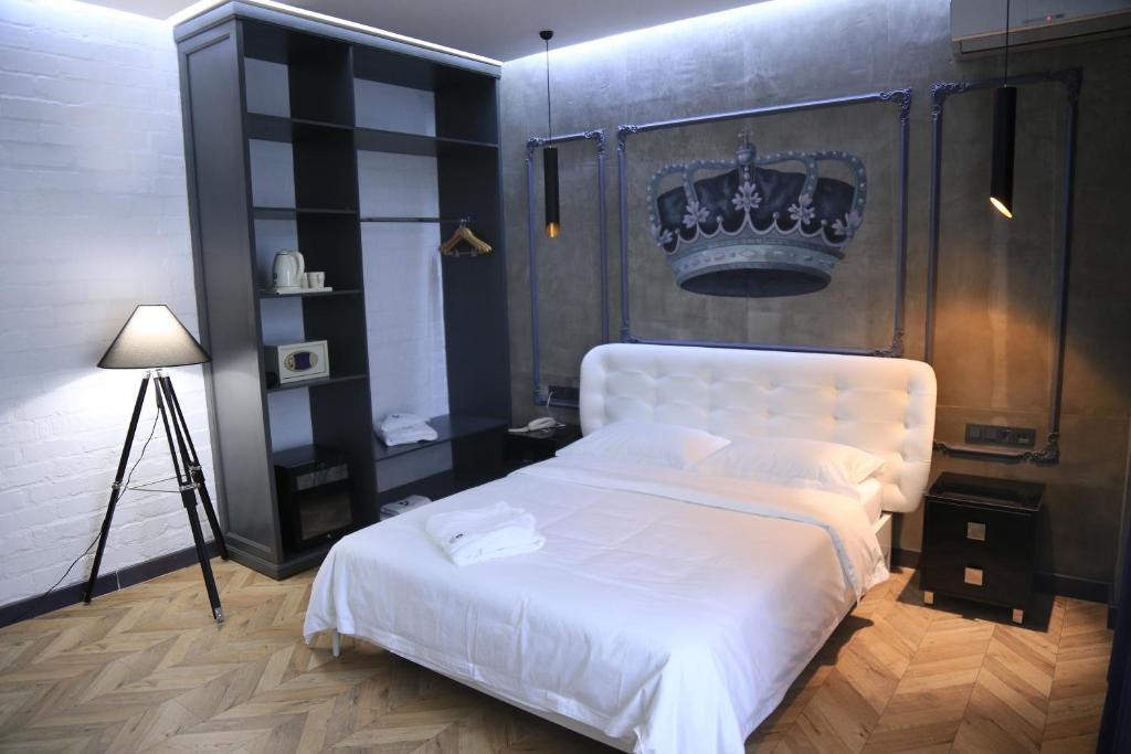 比什凯克比什凯克布古酒店的卧室配有白色床,上面有冠
