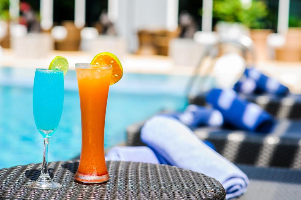 芭堤雅市中心芭堤雅选择酒店的坐在游泳池畔的桌子上享用2杯鸡尾酒