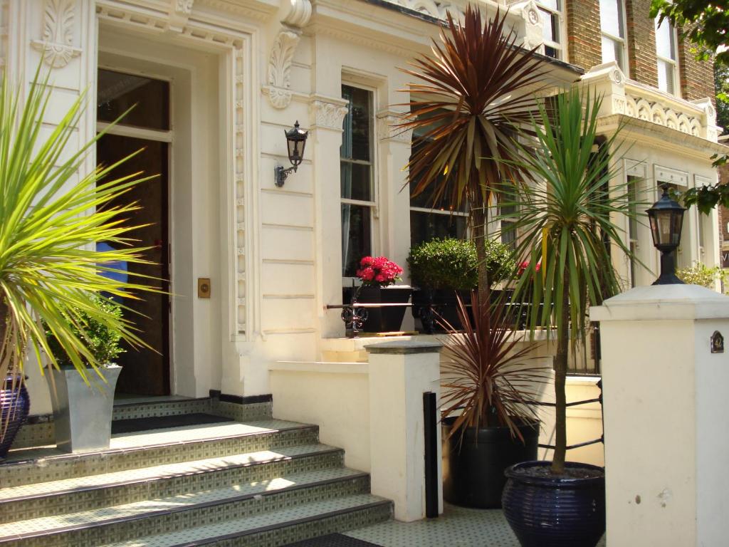 伦敦伦敦维森特酒店的一座白色房子,在台阶上种有盆栽植物