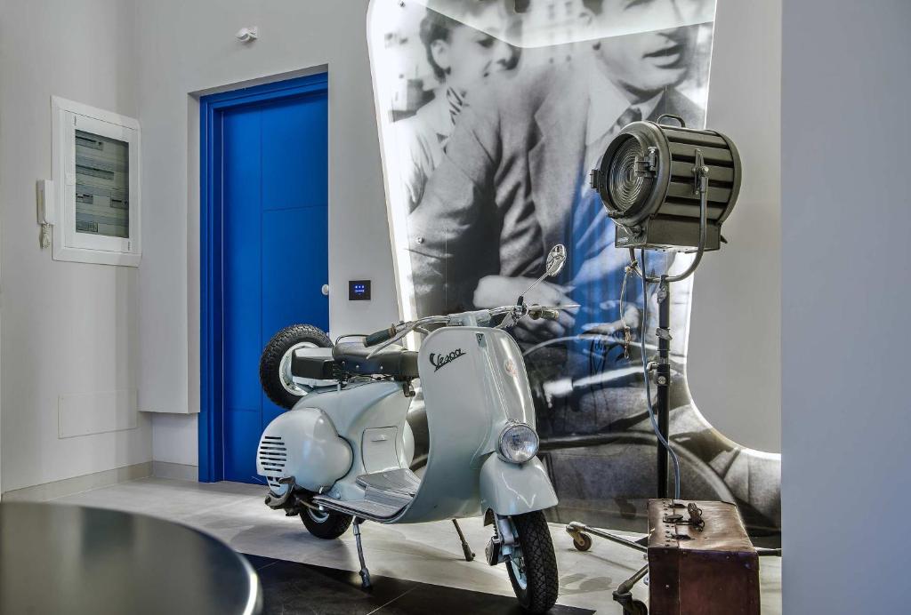 罗马威尼托大街尊贵旅馆的停在一个蓝色门的房间的摩托车