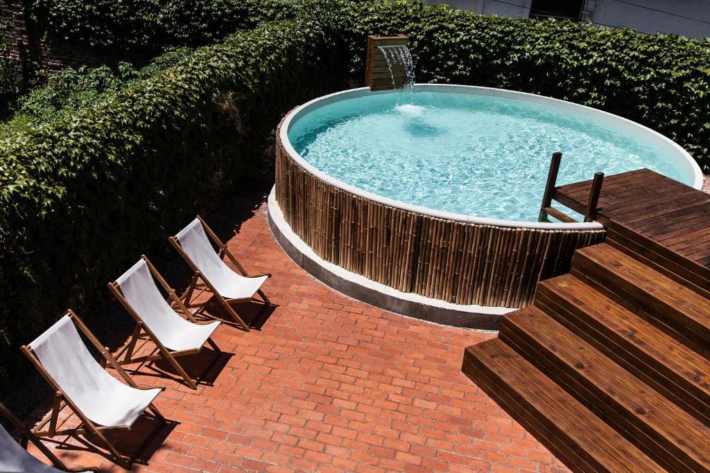 圣伊西德罗Hotel Alto San Isidro的热水浴池配有椅子、桌子和楼梯