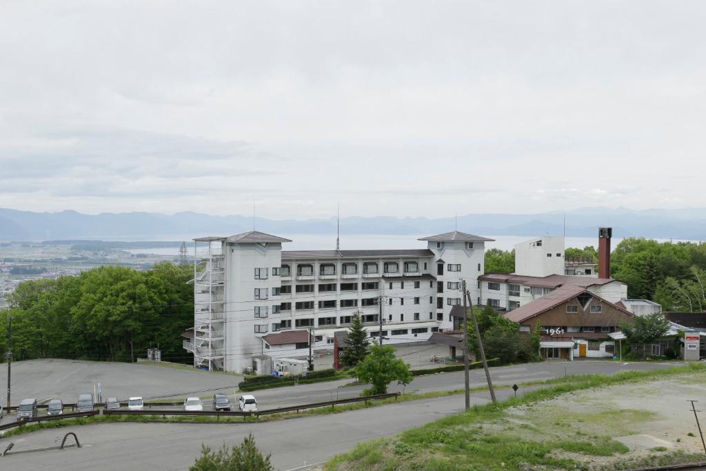 猪苗代町猪苗代町日式旅馆的一座白色的大建筑,前面设有停车场