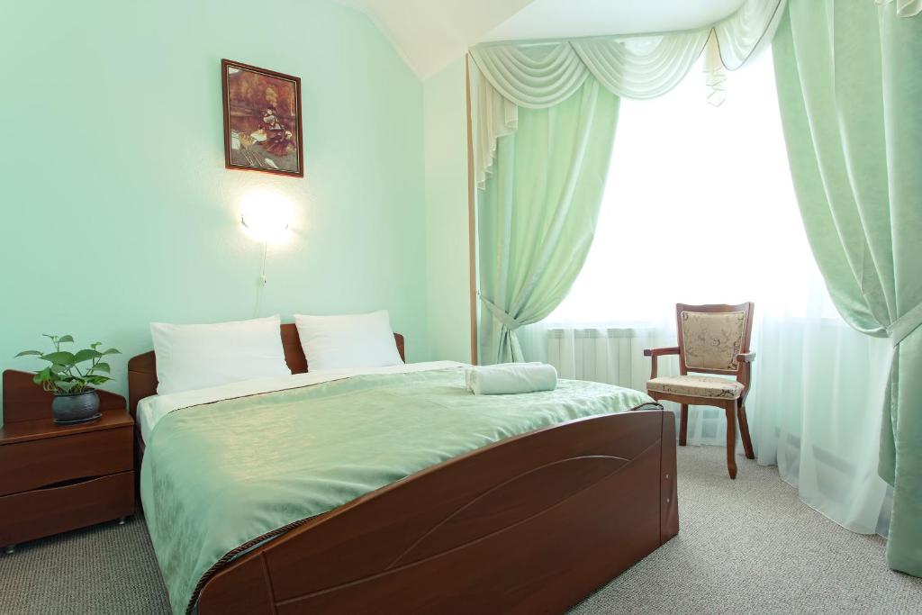 顿河畔罗斯托夫洲际大酒店的卧室配有床、椅子和窗户。