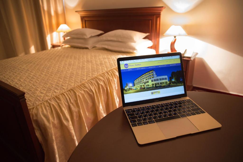 拉克塔希圣巴尼亚卢卡拉克塔奇酒店的坐在酒店房间桌子上的笔记本电脑