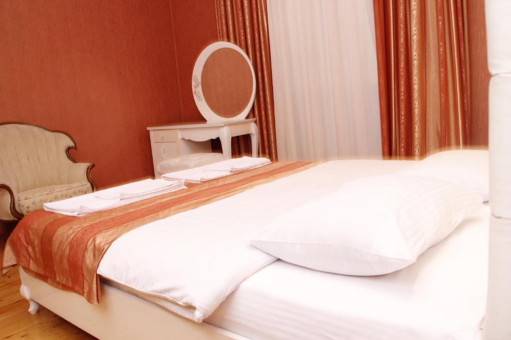 巴库巴库布提克迷你酒店的卧室配有一张带镜子的白色大床