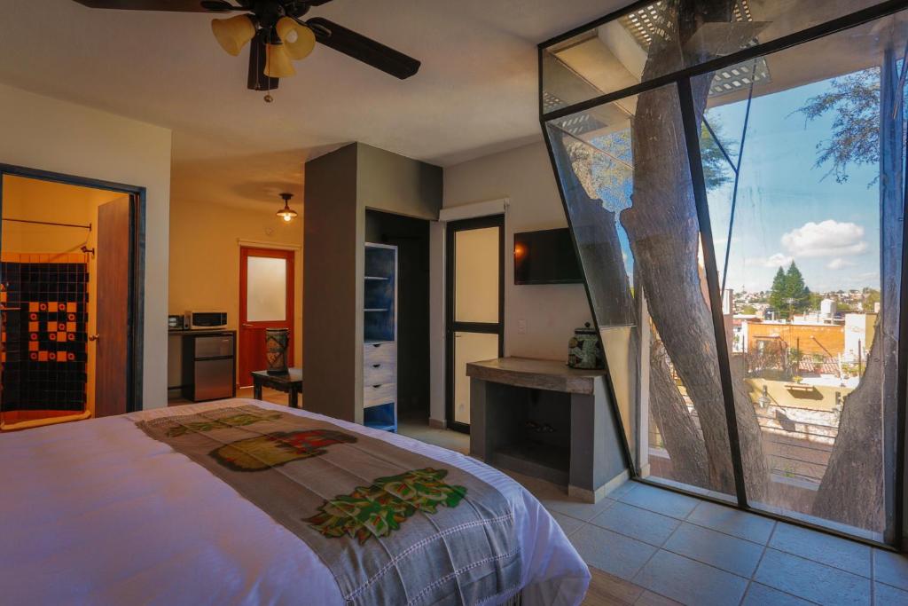 圣米格尔-德阿连德Casa Naré Adults Only的一间卧室设有一张床和一个大型玻璃窗