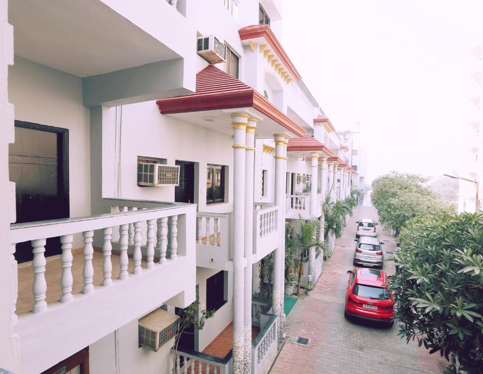 马图拉Hotel Kridha Residency - Opposite Prem Mandir Vrindavan的一条有白色建筑和红色汽车的街道