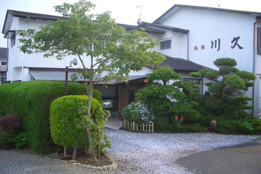 指宿市Family Ryokan Kawakyu with Showa Retro的建筑物前的小树