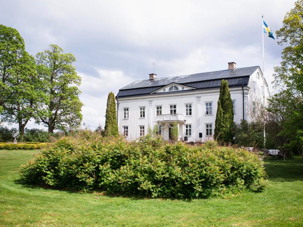 Skirö沃丽碧庄园酒店的白色的房子,上面有旗帜