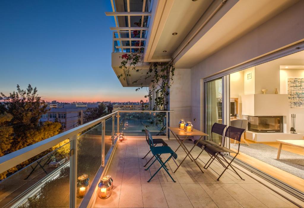雅典斯卡莱套房酒店的设有一个配有桌椅并享有美景的阳台。