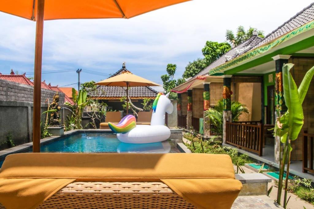 蓝梦岛雷诺阿塔旅馆的游泳池配有充气泳池玩具和遮阳伞