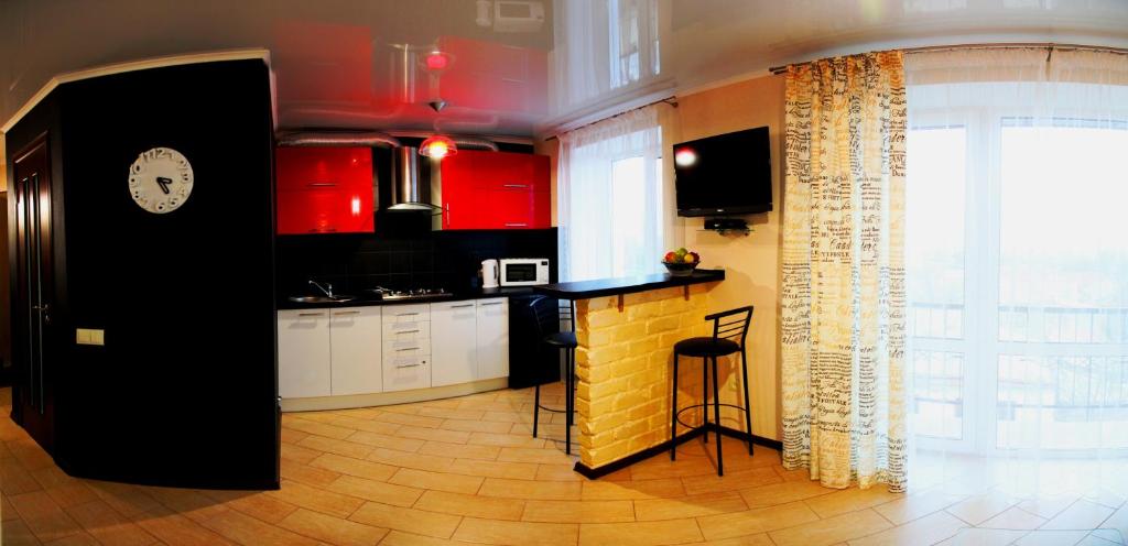 尼古拉耶夫Студия и отдельная спальня в Центре的厨房配有红色橱柜和黑色柜台