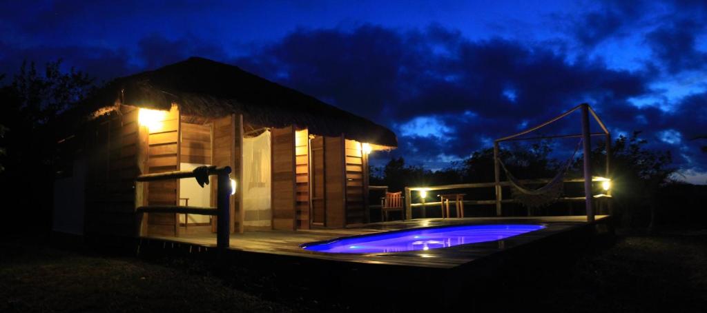 AbadiaPura Vida Bahia的一座小建筑,晚上设有游泳池