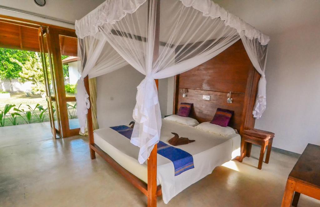 坦加拉桑吉士海边小屋的一间卧室配有一张带天蓬的床