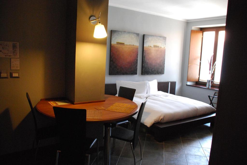 奇列克罗纳格罗萨酒店的卧室配有1张床、1张桌子、1张床和1张桌子及椅子