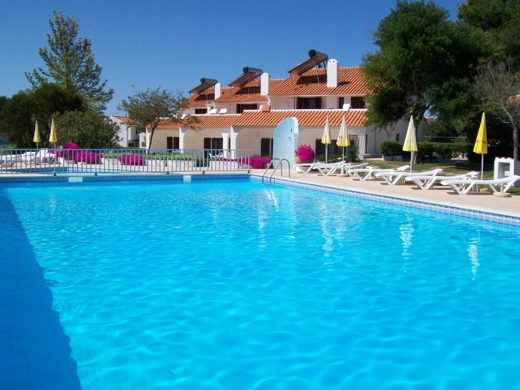 阿尔布费拉Apartamentos Vale de Carros by Umbral的一座大蓝色游泳池,位于房子前
