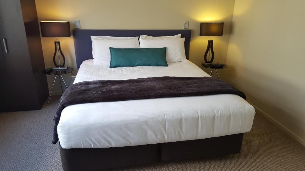 陶波湖帆汽车旅馆的一间卧室配有一张带蓝色枕头的大床