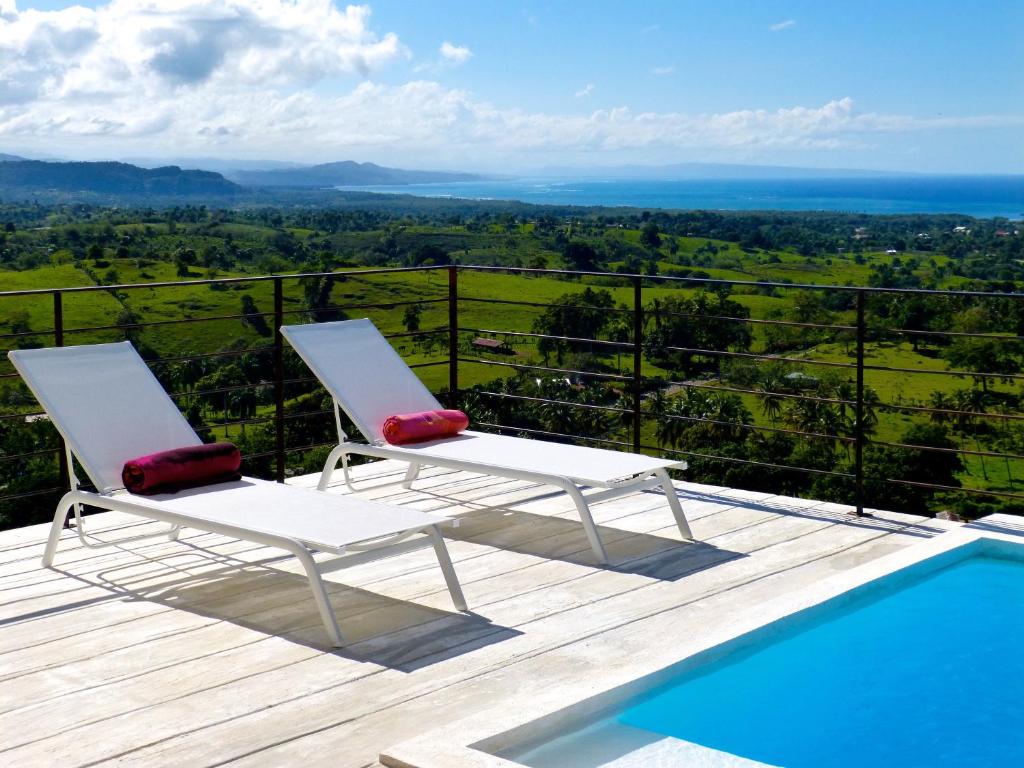 里奥圣胡安Villa Vertigo-Vista Linda的游泳池旁的甲板上摆放着两把椅子