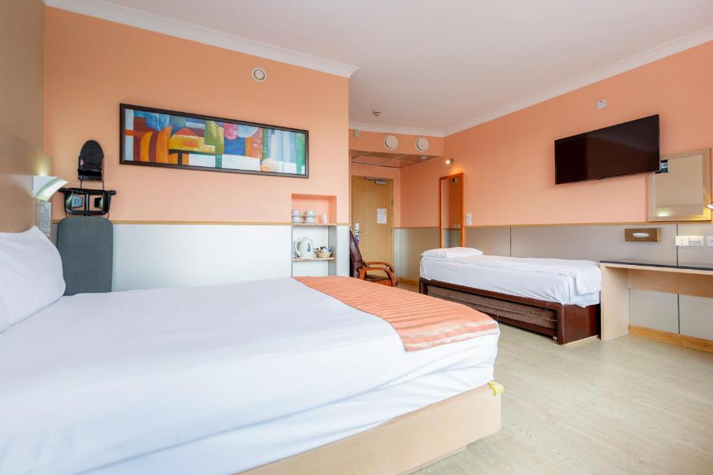 哈罗哈罗欧旅尊贵酒店的酒店客房设有两张床和一台平面电视。