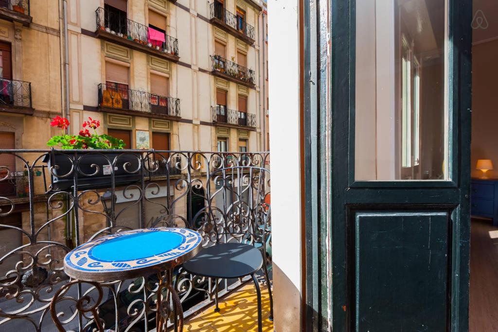 隆达Apartamento Almendra BAJO的阳台配有桌椅,与大楼相连