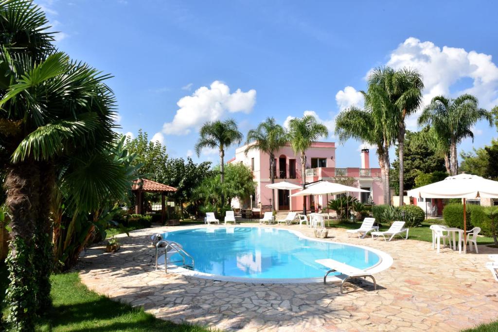 梅萨涅B&B Villa Anastasia Club的棕榈树屋前的游泳池